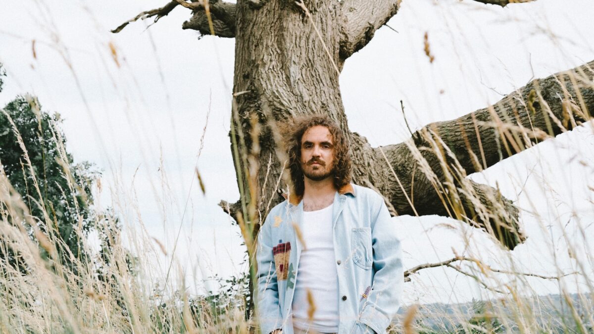 BLAIR DUNLOP STANDING IN FRONT OF A TREE
